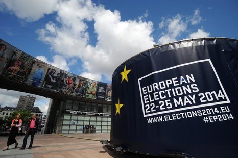 People walk in front of visuals promoting the European elections in front of the European Parliament in Brussels May 24, 2014. REUTERS/Eric People walk in front of visuals promoting the European elections in front of the European Parliament in Brussels May 24, 2014. REUTERS/Eric