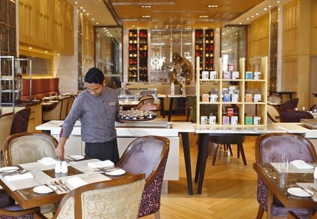 An employee sets a table inside a restaurant at the Crown Plaza hotel, run by the InterContinental Hotels Group (IHG), in New Delhi January An employee sets a table inside a restaurant at the Crown Plaza hotel, run by the InterContinental Hotels Group (IHG), in New Delhi January
