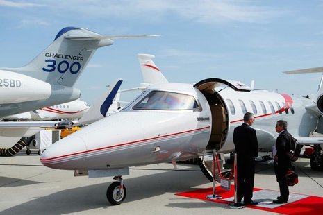 Visitors talk in front of a Bombardier Challenger aircraft in the static display area during the annual European Business Aviation Conventio Visitors talk in front of a Bombardier Challenger aircraft in the static display area during the annual European Business Aviation Conventio