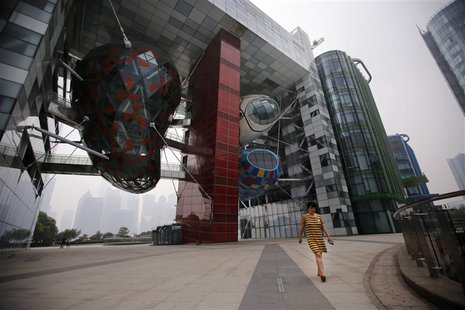 A woman walks along Block 11 area at Huangphu River in Shanghai May 25, 2014. REUTERS/Carlos Barria A woman walks along Block 11 area at Huangphu River in Shanghai May 25, 2014. REUTERS/Carlos Barria