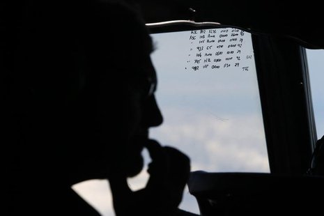 A crew member aboard a Royal New Zealand Air Force P-3K2 Orion aircraft is pictured alongside handwritten notes of other search craft in the A crew member aboard a Royal New Zealand Air Force P-3K2 Orion aircraft is pictured alongside handwritten notes of other search craft in the