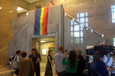 A rainbow flag is unfurled at the Outagamie County Administration Building June 9, 2014, as same-sex couples are allowed to begin filing paperwork for marriages. (Photo from: FOX 11). A rainbow flag is unfurled at the Outagamie County Administration Building June 9, 2014, as same-sex couples are allowed to begin filing paperwork for marriages. (Photo from: FOX 11).