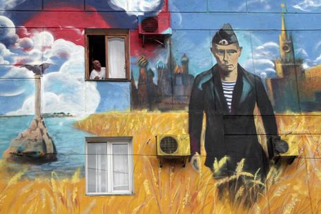 A man looks out of his window surrounded by a recently created piece of graffiti depicting the Kremlin, Russia's President Vladimir Putin and the Russian flag, on the wall of a residential building in More...
CREDIT: REUTERS/STRINGER/FILES A man looks out of his window surrounded by a recently created piece of graffiti depicting the Kremlin, Russia's President Vladimir Putin and the Russian flag, on the wall of a residential building in More...
CREDIT: REUTERS/STRINGER/FILES