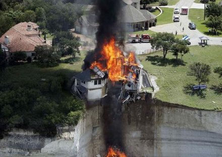 Smoke rises from a house deliberately set on fire, days after part of the ground it was resting on collapsed into Lake Whitney, Texas June 13, 2014. Credit: Reuters/Brandon Wade Smoke rises from a house deliberately set on fire, days after part of the ground it was resting on collapsed into Lake Whitney, Texas June 13, 2014. Credit: Reuters/Brandon Wade