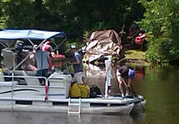 A gold Lincoln Navigator SUV with heavy front end damage is covered by a tarp, and being towed from the Eau Claire River in Schofield, by the Grand Avenue Bridge 6/17/14 A gold Lincoln Navigator SUV with heavy front end damage is covered by a tarp, and being towed from the Eau Claire River in Schofield, by the Grand Avenue Bridge 6/17/14