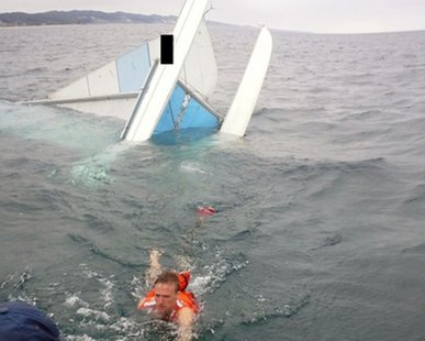 One of four persons on a capsized sailboat in Lake Michigan off of Tunnel Park on Holland's North Side is rescued by Coast Guard staffers on June 20, 2014. (photo courtesy US Coast Guard) One of four persons on a capsized sailboat in Lake Michigan off of Tunnel Park on Holland's North Side is rescued by Coast Guard staffers on June 20, 2014. (photo courtesy US Coast Guard)