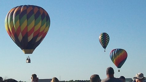 Hot Air balloons maneuver over Kellogg Field aiming for two big markers on the ground. Hot Air balloons maneuver over Kellogg Field aiming for two big markers on the ground.