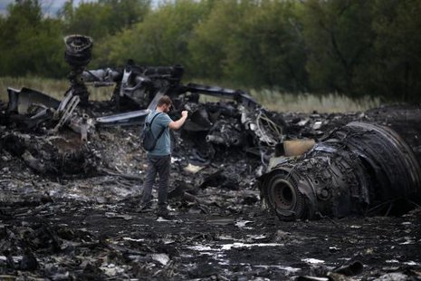 A journalist takes photographs at the site of Thursday's Malaysia Airlines Boeing 777 plane crash near the settlement of Grabovo, in the Donetsk region July 18, 2014.
REUTERS/Maxim Zmeyev A journalist takes photographs at the site of Thursday's Malaysia Airlines Boeing 777 plane crash near the settlement of Grabovo, in the Donetsk region July 18, 2014.
REUTERS/Maxim Zmeyev