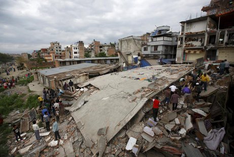 People gather near a collapsed house after a major earthquake in Kathmandu, Nepal April 25, 2015. REUTERS/Navesh Chitrakar